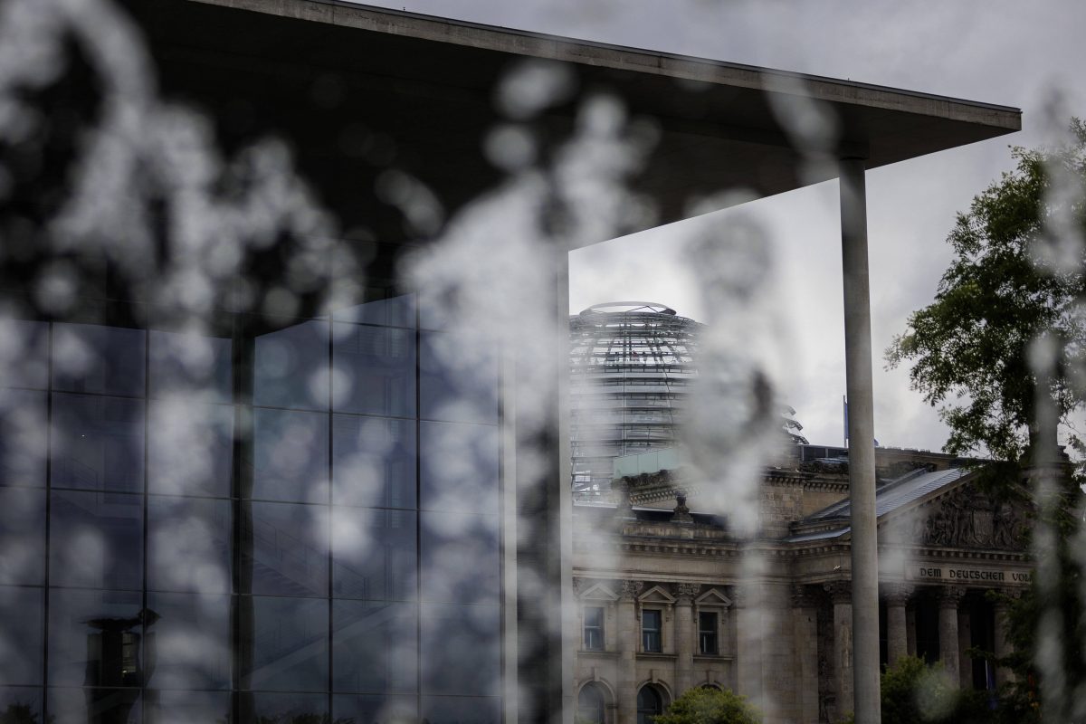 Paul-Loebe-Haus und der Deutsche Bundestag hinter Scheibe mit Regenwasser