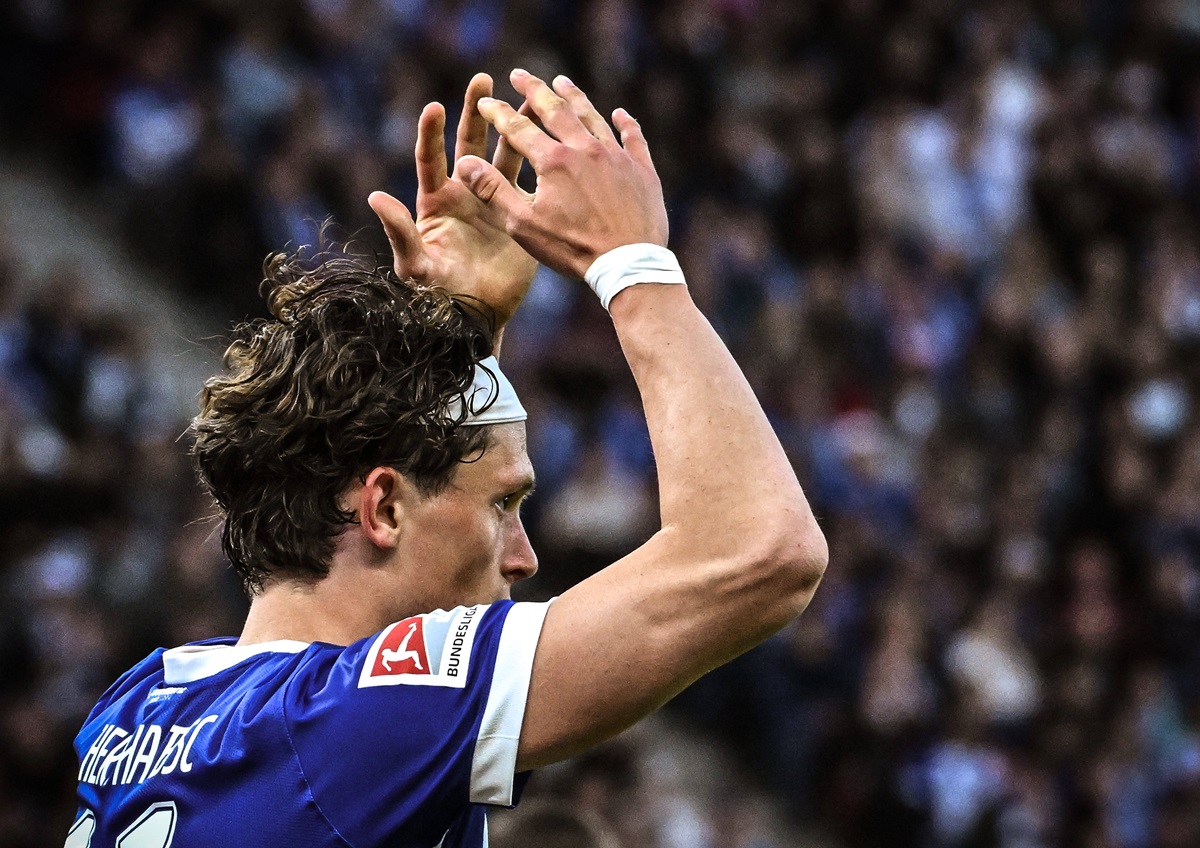 Fabian Reese von Hertha BSC hebt die Arme über den Kopf.