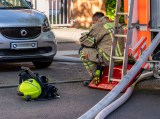 Ein Berliner Feuerwehrmann sitzt neben einem Einsatzfahrzeug.