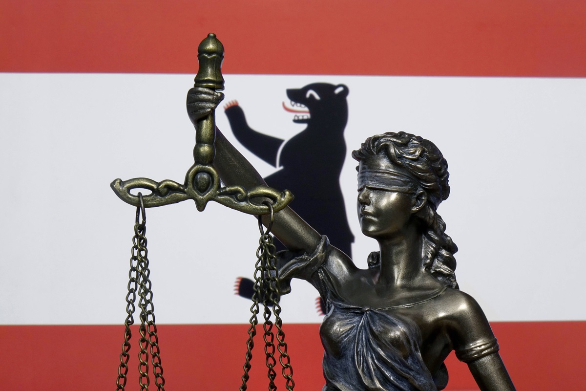 Eine Skulptur der Justitia vor der Berliner Landesfahne.