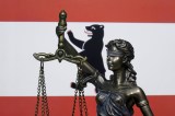 Eine Skulptur der Justitia vor der Berliner Landesfahne.