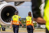 Zwei Zoll-Mitarbeiter stehen auf dem Rollfeld des Flughafens BER.