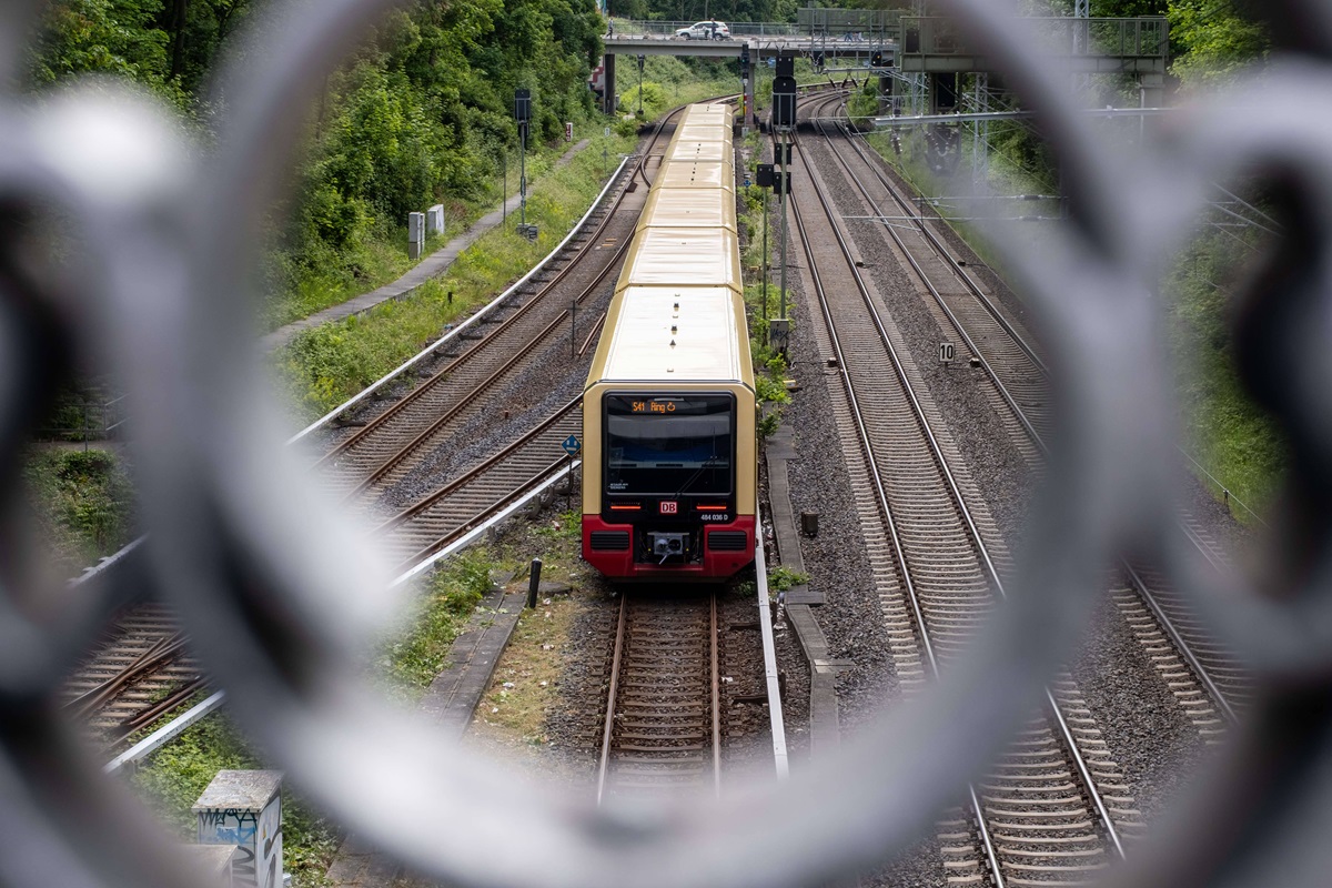 Ein Zug der S-Bahn Berlin durch ein Brückengeländer fotografiert.