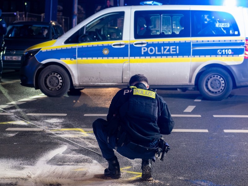 Ein Berliner Polizist macht Markierungen an einer Unfallstelle.