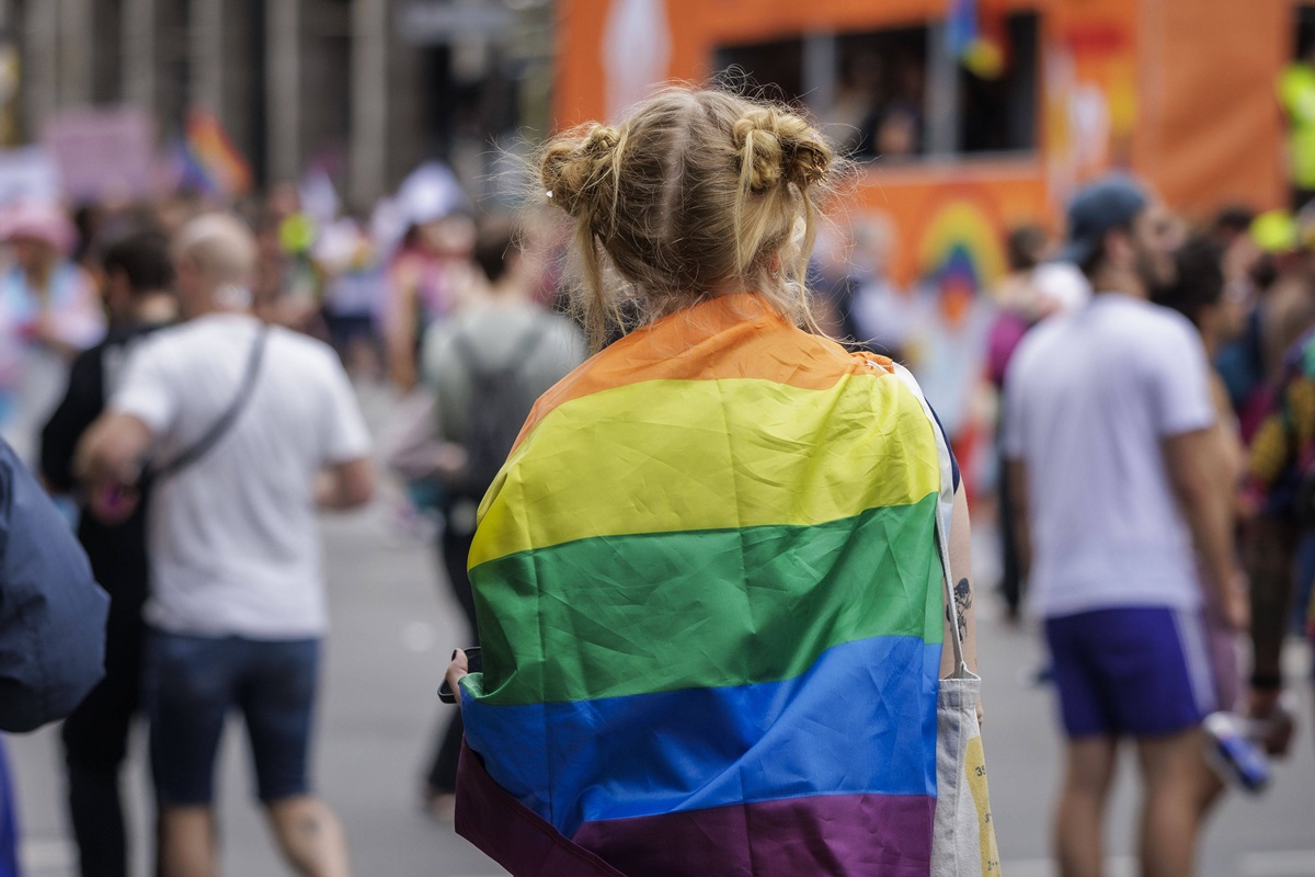 Eine Teilnehmerin blickt beim CSD in Berlin auf die Parade.