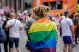 Eine Teilnehmerin blickt beim CSD in Berlin auf die Parade.