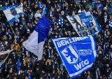 Fans von Hertha BSC schwenken Fahnen.