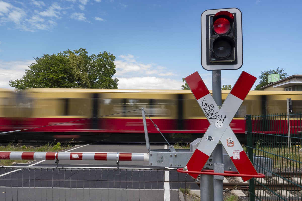 Ein Zug der S-Bahn Berlin fährt über einen Bahnübergang.