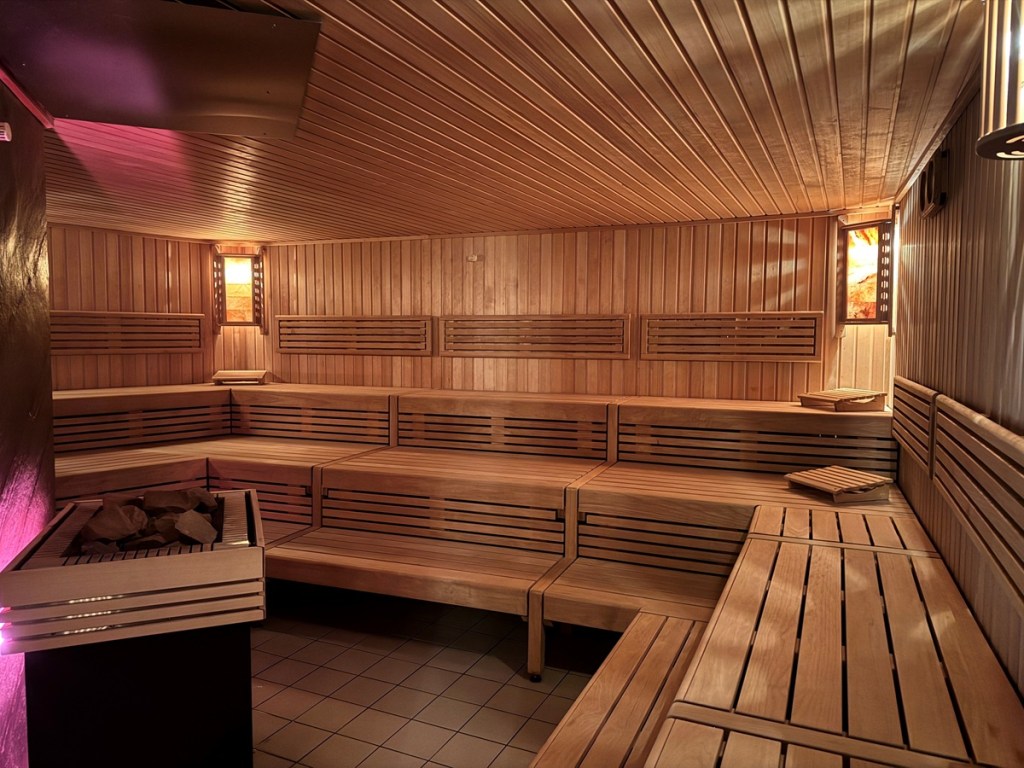 Sauna mit Holzbänken und Aufguss