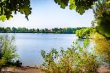 Ausblick auf Badesee zwischen grünen Bäumen
