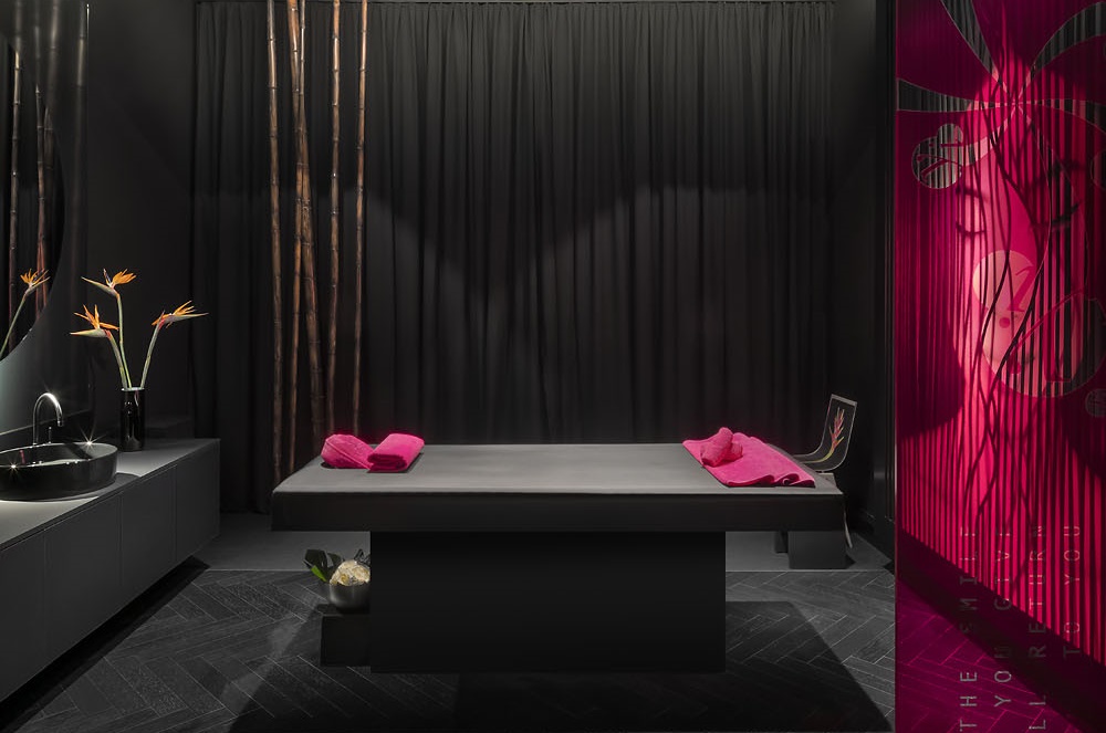 Massageraum in minimalistischem schwarzen und pinken Design